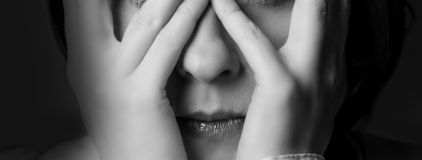 Kobieta zakrywa oczy z lęku